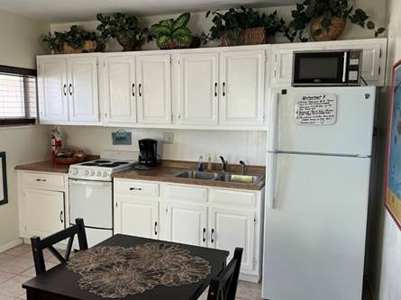 A kitchen with white cabinets

Description automatically generated